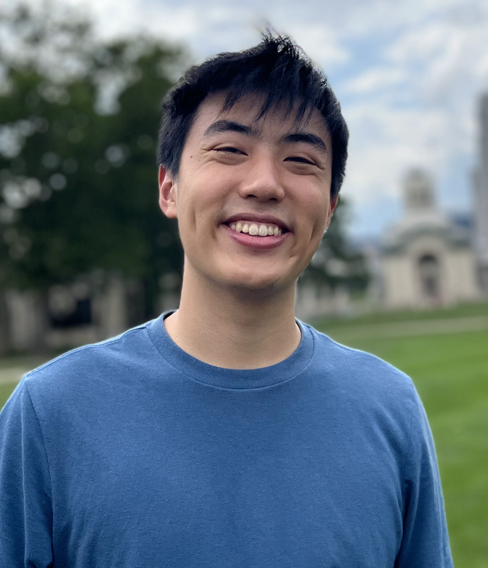 Kenny smiles in front of Carnegie Mellon campus